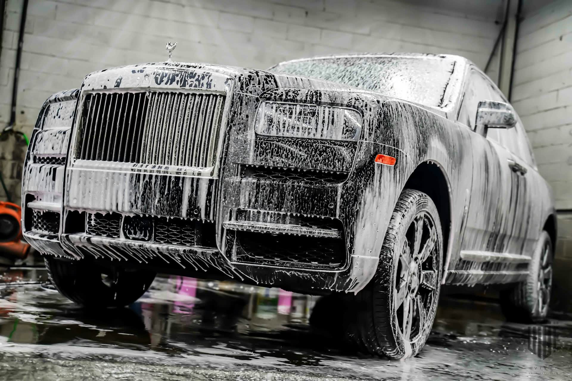 Luxury SUV covered in snow foam during a hand wash